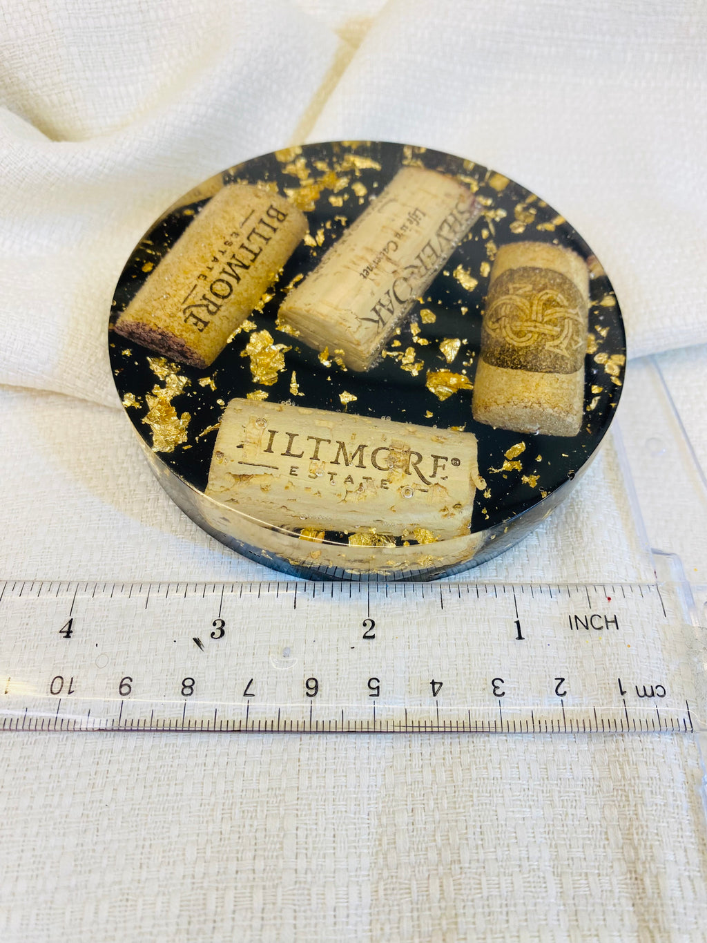 Handmade wine lover gifts, wine cork resin coaster with gold leaf accents and measuring ruler for size reference.