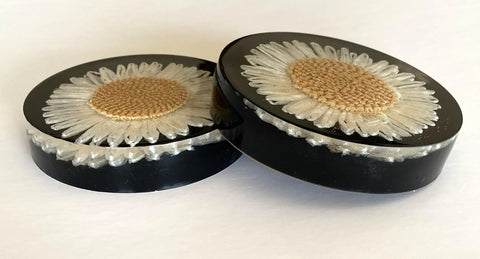 Set of flower resin coasters with strawflowers in glossy black resin, adding elegance to home decor.
