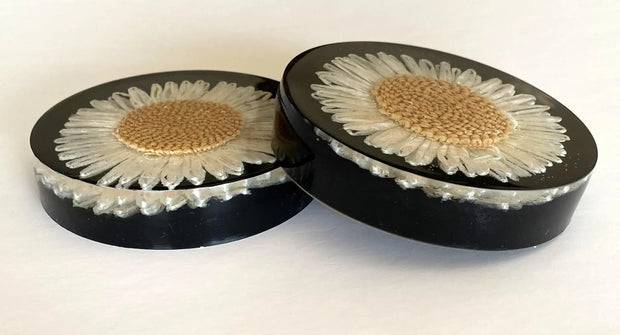 Set of flower resin coasters with strawflowers in glossy black resin, adding elegance to home decor.